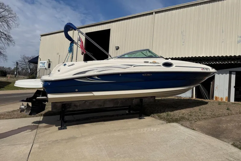 Slide: The Image of 2006 Sea Ray 240 Sundeck boat on display outside a warehouse. - 3