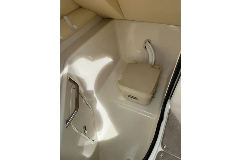 Slide: The Image of 2006 Sea Ray 240 Sundeck interior with portable toilet and storage compartment. - 32