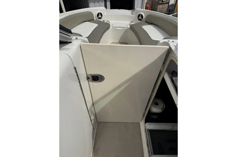 Slide: The Image of 2006 Sea Ray 240 Sundeck interior with open storage compartment and seating area. - 34