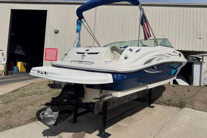 Slide: The Image of 2006 Sea Ray 240 Sundeck boat on display outside a warehouse. - 4