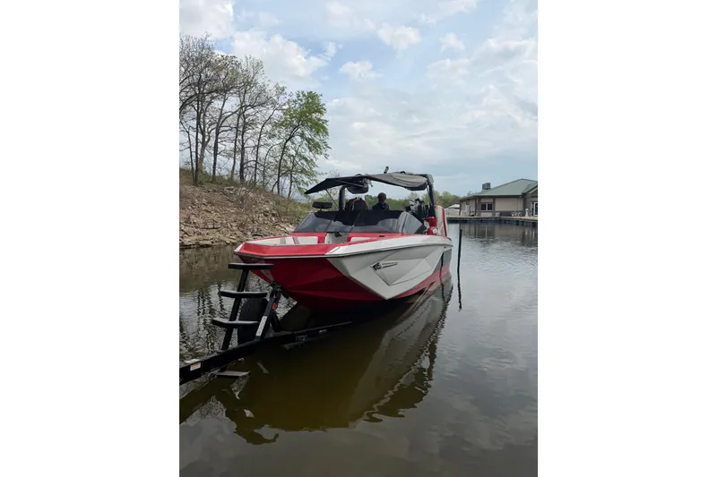 The Image of 2023 Nautique Super Air Nautique G23 boat docked on a calm lake. - 0