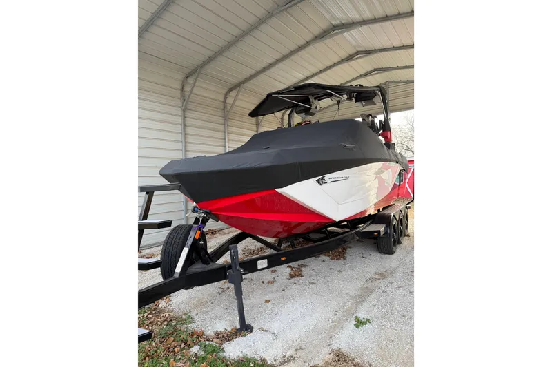 Slide: The Image of 2023 Nautique Super Air Nautique G23 boat under cover in a metal shelter. - 2
