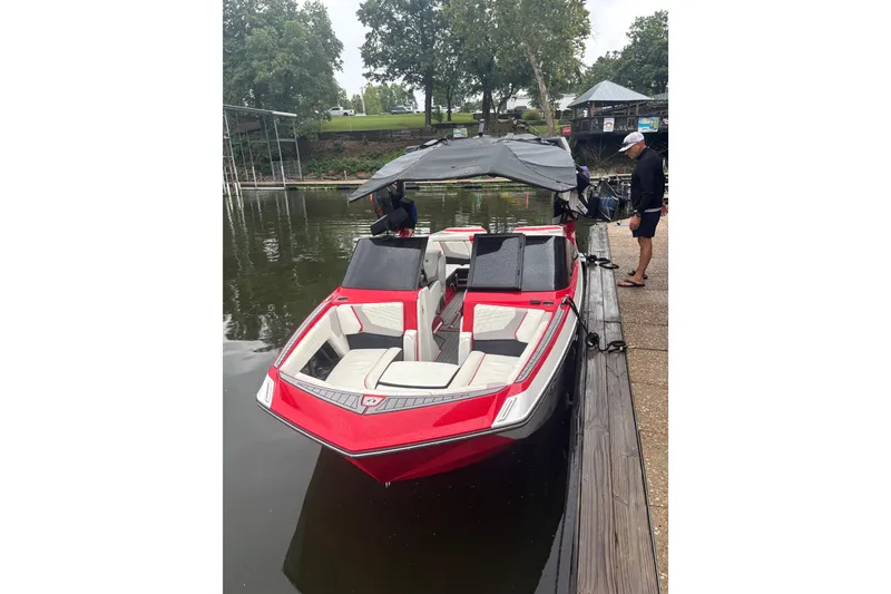 Slide: The Image of 2023 Nautique Super Air Nautique G23 boat docked, featuring red and white design. - 3