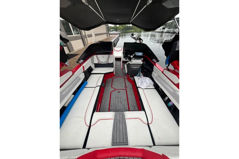 Slide: The Image of 2023 Nautique Super Air Nautique G23 interior with red and white seating, docked by water. - 4