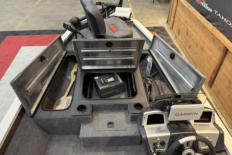 Slide: The Image of 2025 Tracker Pro Team 175 boat interior with Garmin electronics and storage compartments open. - 11