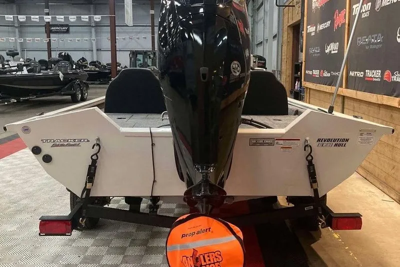Slide: The Image of 2025 Tracker Pro Team 175 boat in showroom, rear view with outboard motor. - 3