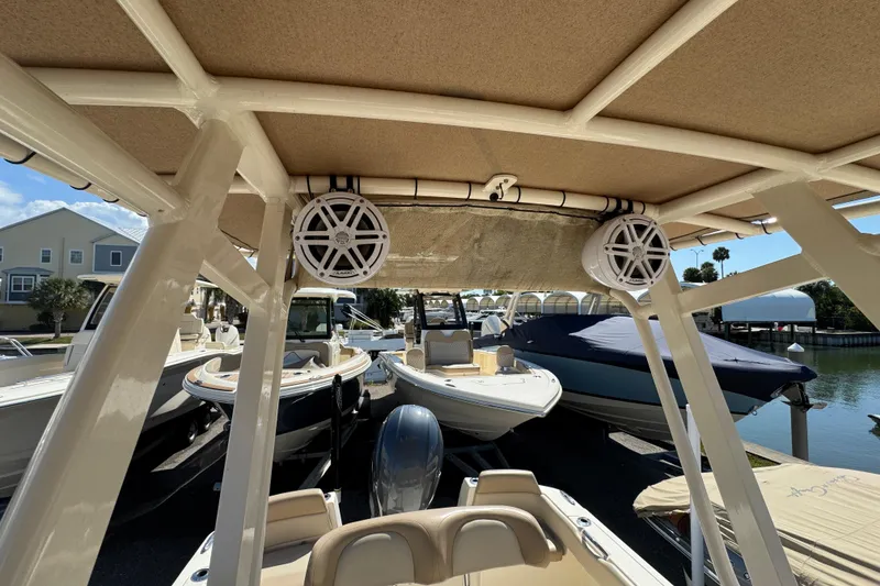 Slide: The Image of 2023 Scout 195 Sportfish boat interior with speakers, docked among other boats. - 13