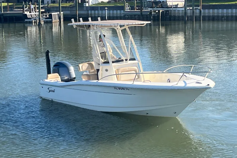 Slide: The Image of 2023 Scout 195 Sportfish boat on calm water, featuring sleek design and modern amenities. - 5