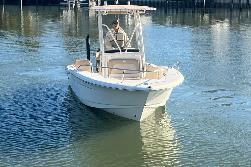 Slide: The Image of 2023 Scout 195 Sportfish boat on calm water, featuring a sleek design. - 6