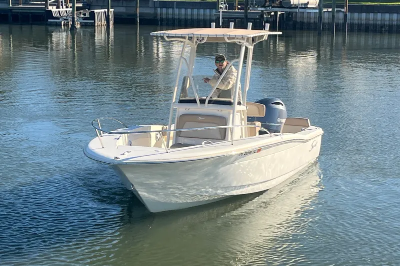 Slide: The Image of 2023 Scout 195 Sportfish boat on calm water, featuring a sleek design and modern amenities. - 7