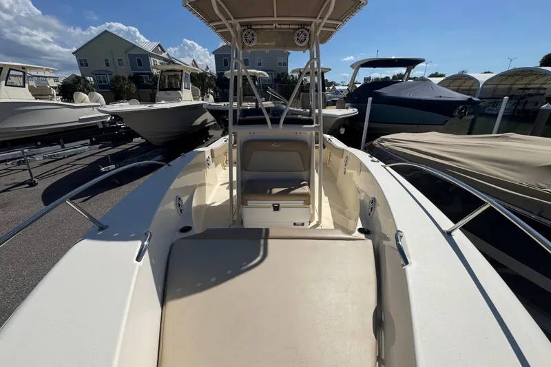 Slide: The Image of 2023 Scout 195 Sportfish boat with spacious deck and seating, docked under clear skies. - 9