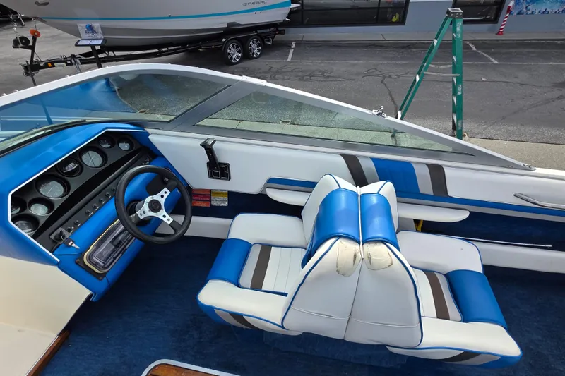 Slide: The Image of Interior of a 1990 Sea Ray 210 Bow Rider with blue and white seating. - 10