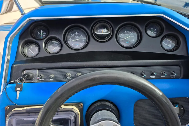 Slide: The Image of Dashboard of a 1990 Sea Ray 210 Bow Rider boat with gauges and controls. - 12