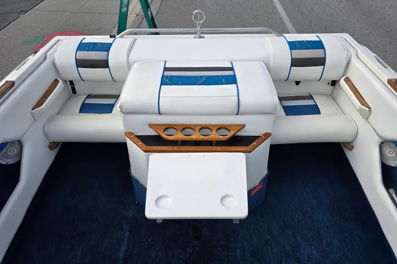 Slide: The Image of 1990 Sea Ray 210 Bow Rider interior with white and blue seating, wooden accents. - 15