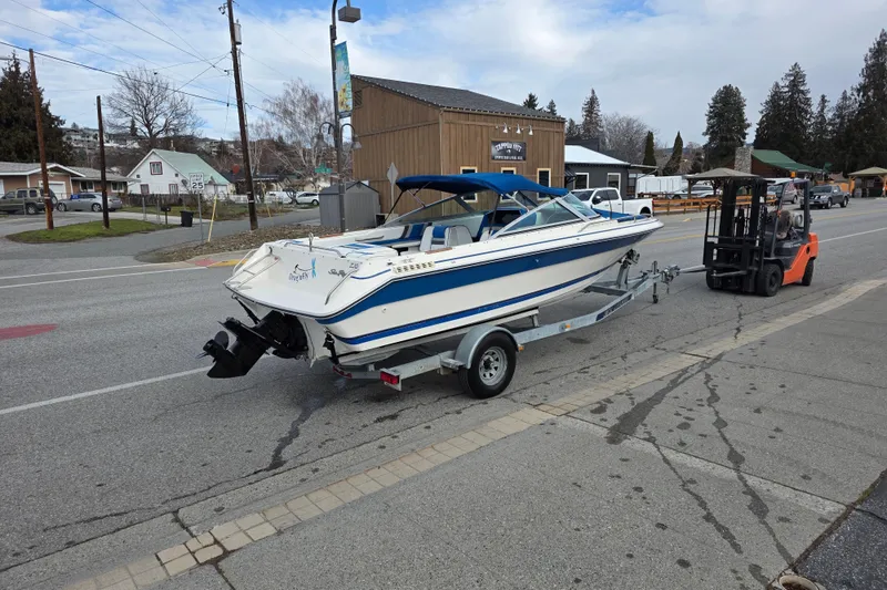 Slide: The Image of 1990 Sea Ray 210 Bow Rider on trailer, street view with forklift. - 4