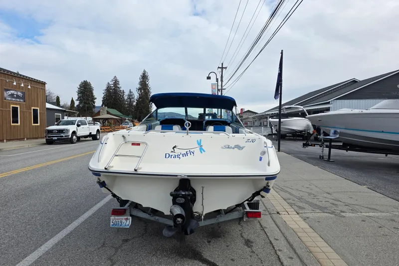 Slide: The Image of 1990 Sea Ray 210 Bow Rider boat parked on street, rear view. - 5