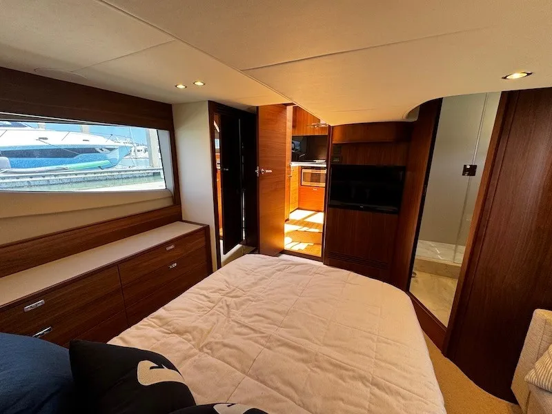 Slide: The Image of Luxurious cabin with a double bed, wooden furnishings, and a window overlooking the water. - 42