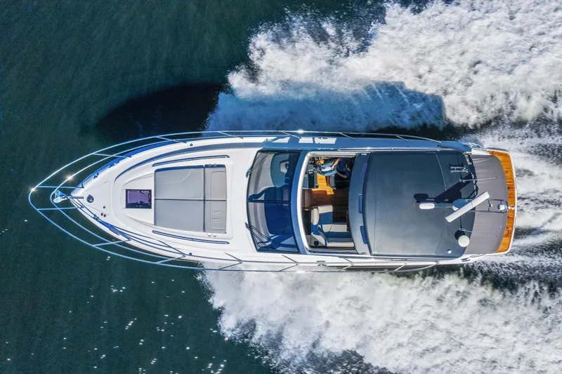 Slide: The Image of Aerial view of a white yacht speeding across the water, with visible deck and cockpit. - 9