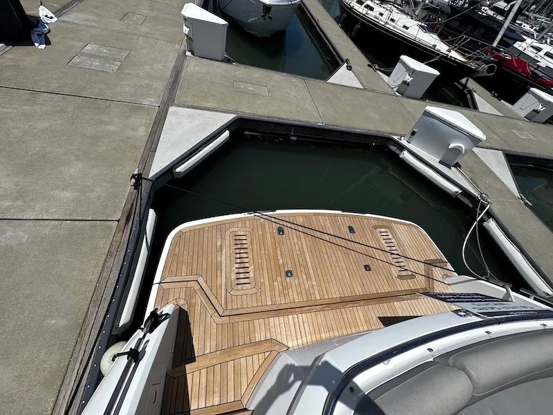 Slide: The Image of The image shows the stern of a 2020 Princess V50 yacht docked at a marina. - 43