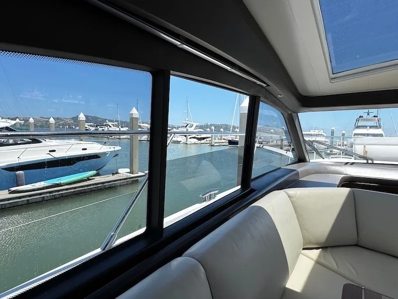 Slide: The Image of Interior view of a luxury yacht with beige sofa and large windows overlooking a marina. - 22