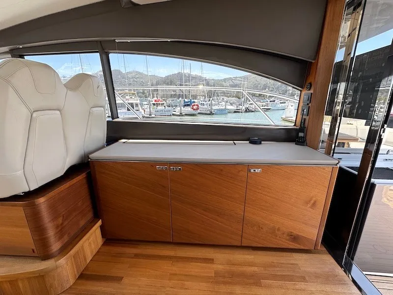 Slide: The Image of Interior of a 2020 Princess V50 with wooden flooring and cabinets, overlooking a marina. - 17
