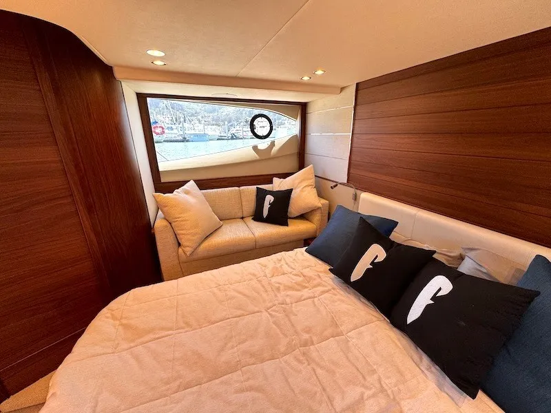 Slide: The Image of Luxurious cabin of the 2020 Princess V50 with a large bed and elegant wood paneling. - 39
