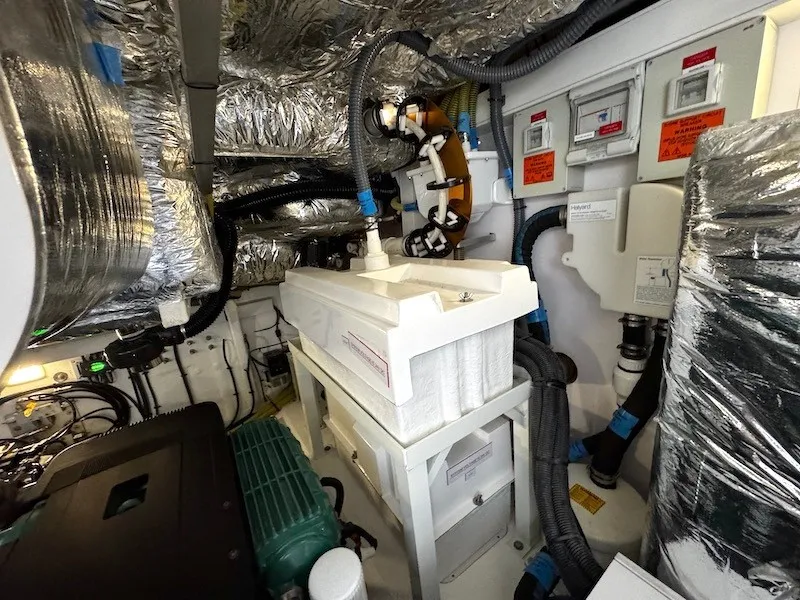 Slide: The Image of The engine room of a 2020 Princess V50 features complex piping and insulation. - 48