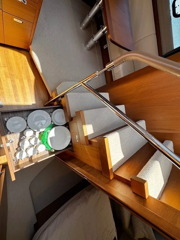 Slide: The Image of Interior of a 2020 Princess V50 with wooden stairs and dishes in a drawer. - 33