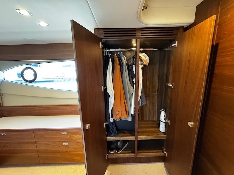 Slide: The Image of A sleek wooden wardrobe with clothes and shoes, in a luxurious boat cabin. - 44