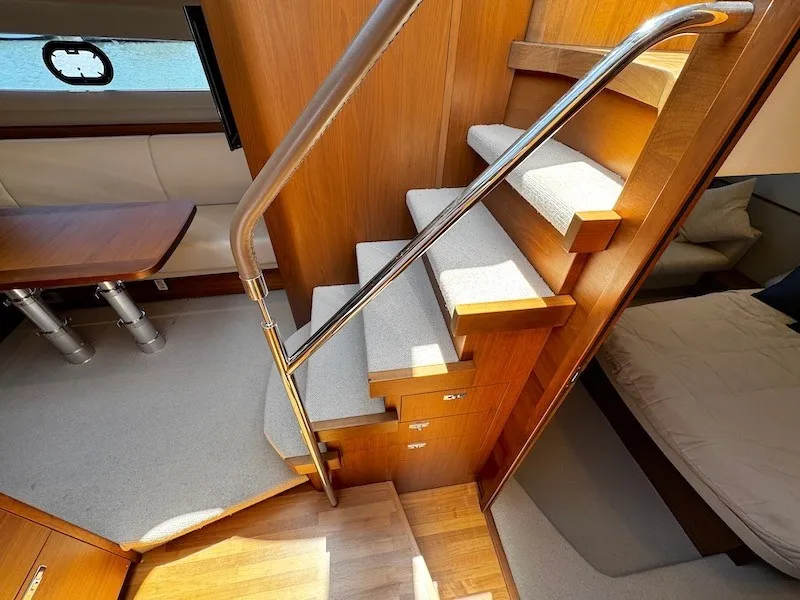Slide: The Image of Interior of a luxury yacht with wooden stairs, cozy dining area, and sleeping quarters. - 32
