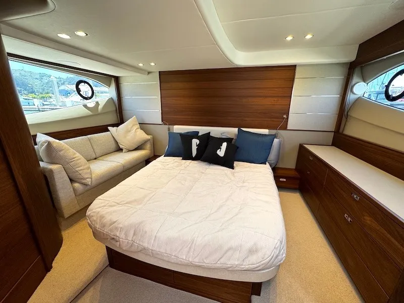 Slide: The Image of Luxurious cabin of the 2020 Princess V50 with a large bed, sofa, and wood accents. - 37