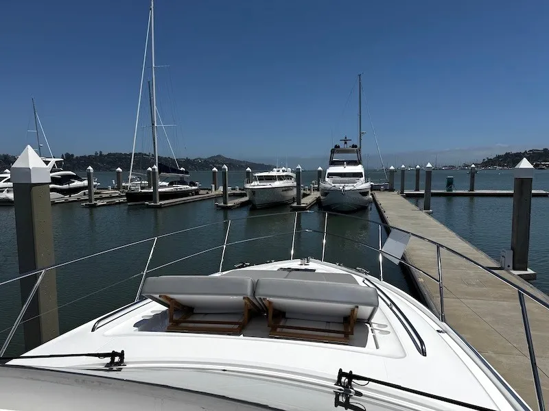Slide: The Image of A luxury yacht docked at a serene harbor with several other boats anchored nearby. - 24