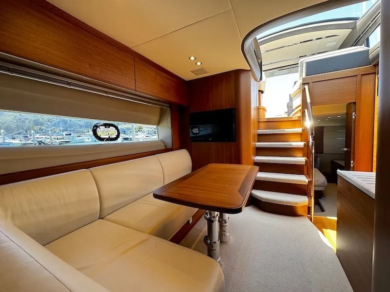 Slide: The Image of Interior of a luxury yacht with elegant seating area, wooden table, and stairs to the upper level. - 34
