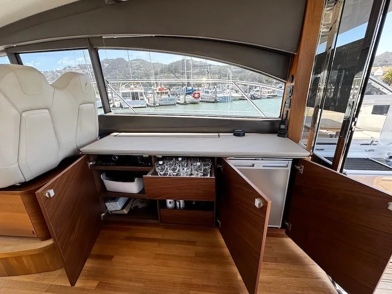 Slide: The Image of Interior of a 2020 Princess V50 with wooden cabinets and glassware, docked at a marina. - 18