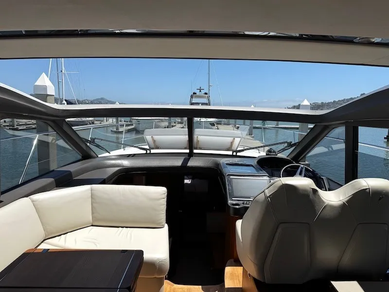 Slide: The Image of Interior view of a luxury yacht with white leather seating and large windows overlooking a marina. - 23