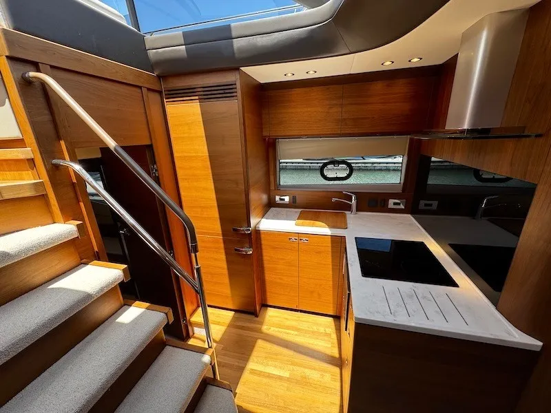 Slide: The Image of The galley of a 2020 Princess V50 yacht with wooden cabinets, stove, and sink. - 30