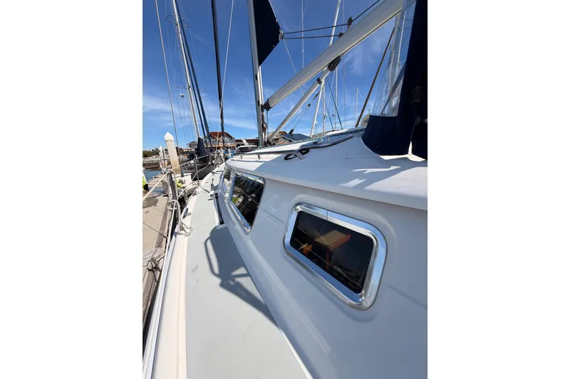 Slide: The Image of 2007 Hunter 44 Deck Salon sailboat docked, showcasing sleek design and windows. - 13