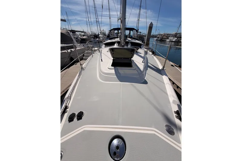 Slide: The Image of 2007 Hunter 44 Deck Salon sailboat docked at marina, showcasing spacious deck and sleek design. - 17