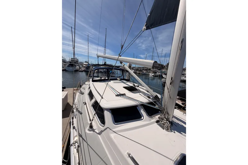 Slide: The Image of 2007 Hunter 44 Deck Salon sailboat docked in a marina under clear blue skies. - 18