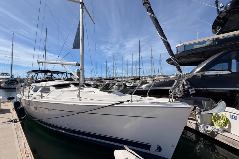 Slide: The Image of 2007 Hunter 44 Deck Salon yacht docked at marina under clear blue sky. - 2
