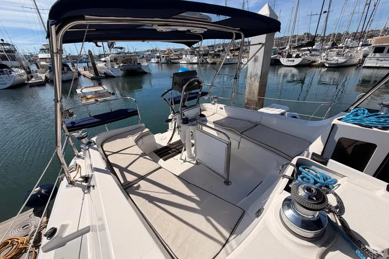 Slide: The Image of 2007 Hunter 44 Deck Salon yacht cockpit with marina view, featuring seating and helm station. - 21