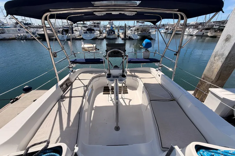 Slide: The Image of 2007 Hunter 44 Deck Salon sailboat cockpit view in marina, showcasing seating and helm. - 22