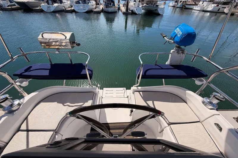 Slide: The Image of 2007 Hunter 44 Deck Salon yacht cockpit with marina view, featuring seating and equipment. - 23