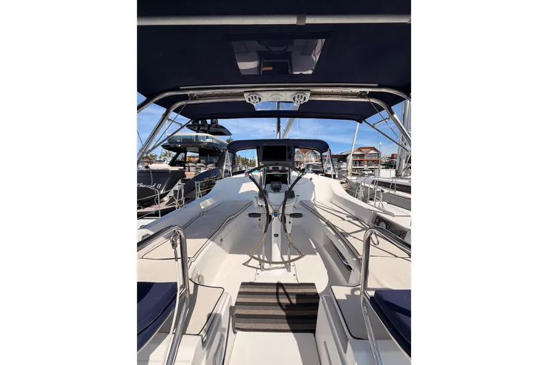 Slide: The Image of 2007 Hunter 44 Deck Salon sailboat cockpit with blue canopy and marina view. - 26