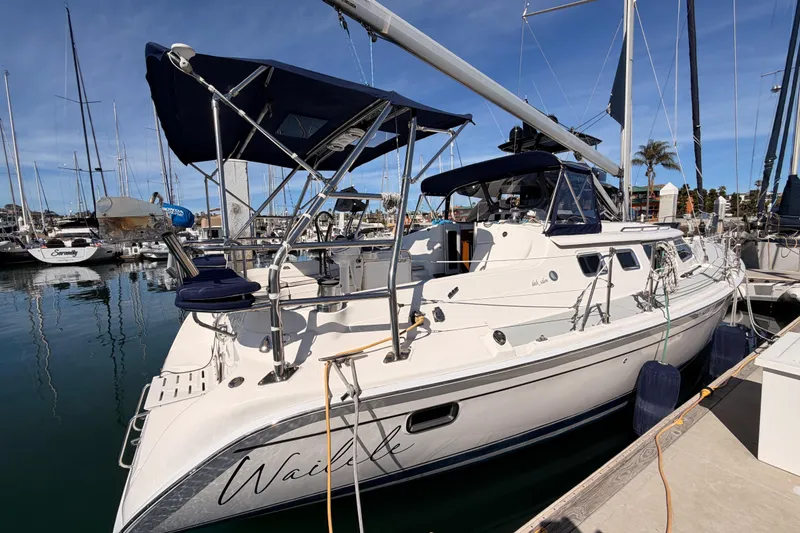 Slide: The Image of 2007 Hunter 44 Deck Salon sailboat docked in marina under clear blue sky. - 3