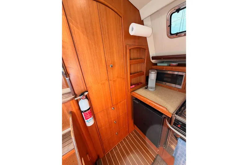 Slide: The Image of 2007 Hunter 44 Deck Salon interior kitchen with wooden cabinetry and appliances. - 37
