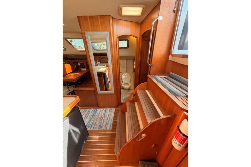 Slide: The Image of 2007 Hunter 44 Deck Salon interior with wooden stairs, mirror, and bathroom view. - 41