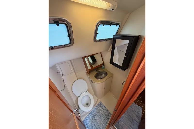 Slide: The Image of Compact bathroom in 2007 Hunter 44 Deck Salon yacht with sink, toilet, and mirror cabinet. - 42