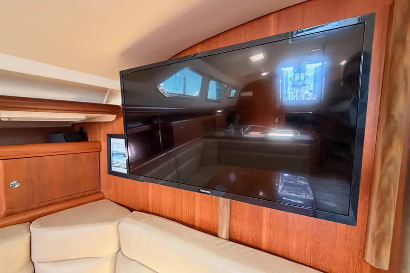 Slide: The Image of Interior of 2007 Hunter 44 Deck Salon with mounted TV and wooden cabinetry. - 50