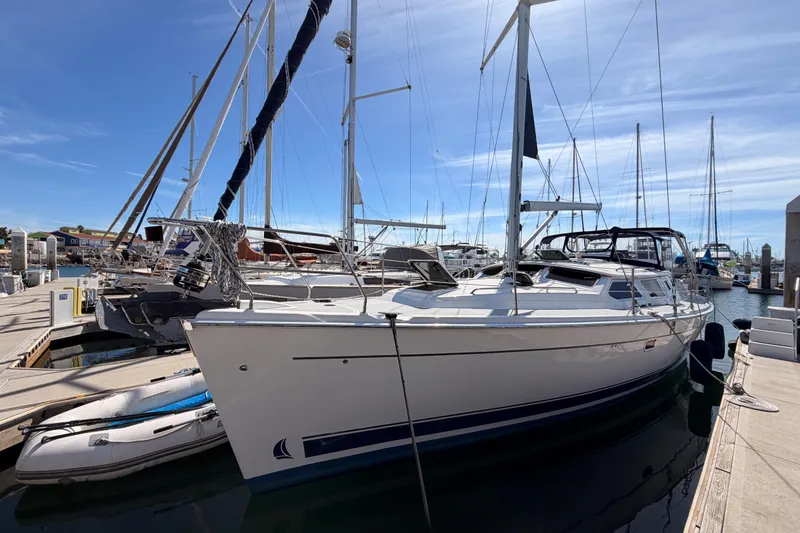 Slide: The Image of 2007 Hunter 44 Deck Salon sailboat docked at marina under clear blue sky. - 6